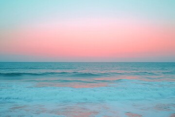 Obraz premium Vibrant pink and blue sky reflecting over calm ocean waves at dusk near the shoreline