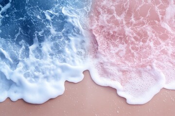 Fototapeta premium Waves crashing on a sandy beach create a beautiful blend of blue and pink during sunset hours