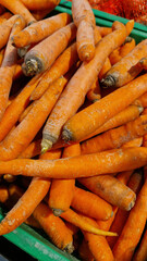 Washed ripe carrots on sale in the store. Carrots close-up. Vegetable crop. A pile of washed carrots in a plastic box, selective focus. Vegetables in the supermarket close-up