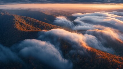 Fototapeta premium Dramatic aerial capture of thick clouds rolling over a mountain range