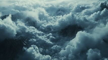 Naklejka premium Dramatic aerial capture of thick clouds rolling over a mountain range