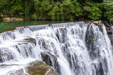 Taiwan Shifen waterfall flowing through lush greenery