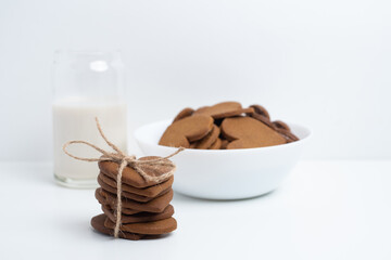 Heart shaped cookies and a glass of milk on a light background. Delicious snack and pastry