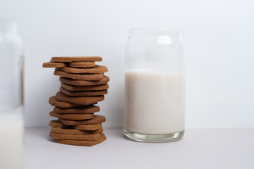 Heart shaped cookies and a glass of milk on a light background. Delicious snack and pastry