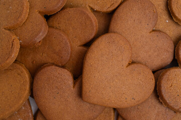 Gingerbread heart cookies on parchment paper. Delicious baking