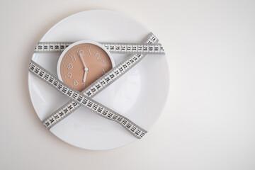 Alarm clock with measuring tapes, copy space. Healthy lifestyle, weight loss