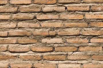 A textured background of a red brick wall with ceramic tiles featuring intricate patterns