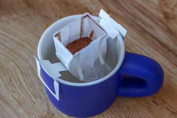 blue cup with a coffee filter on it no water yet