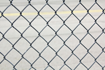 Close-up of a chain link fence with a soft background.