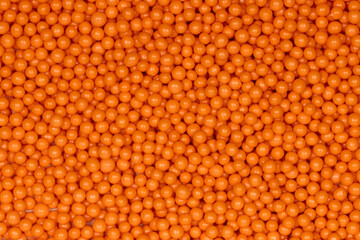 Vibrant Orange Sugar Sprinkles Background: Macro Photography of Decorative Candy Pearls Used for Cake Decoration and Confectionery Garnish