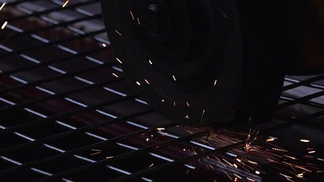 Close up, slow motion view of sparks from the metal fence cutting process with an angle grinder.