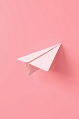 a close up of a paper airplane on a pink background