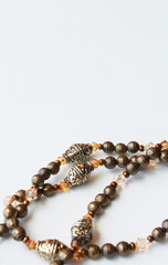 Elegant handcrafted necklace made of brown and bronze beads in vintage style. Sophisticated bijoux close up on white background with copy space available. Women's fashion, female accessory, bijouterie