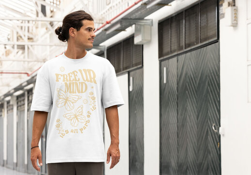 A man showcases a blank short sleeve t-shirt in a stylish, urban setting, highlighting customization options for design.