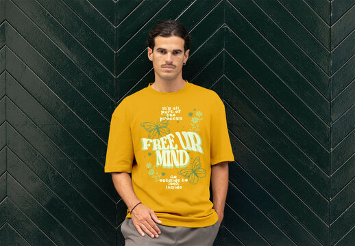 A man confidently models a customizable short sleeve t-shirt on a trendy green chevron background.