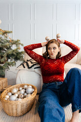 a woman in the Christmas decorated rom with a spruce tree ms Santa