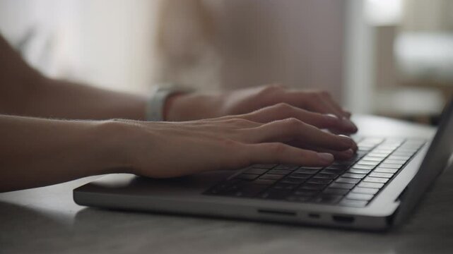 Orbiting around female hands typing on laptop