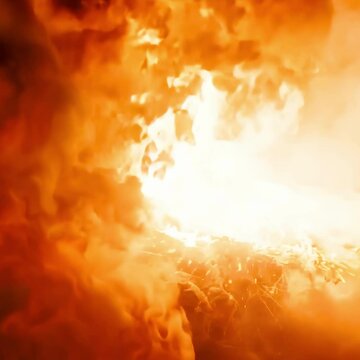 Powerful explosion generating a large cloud of orange smoke, creating a dramatic and intense scene.