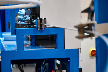 Straightening metal wire with rollers in workshop of factory