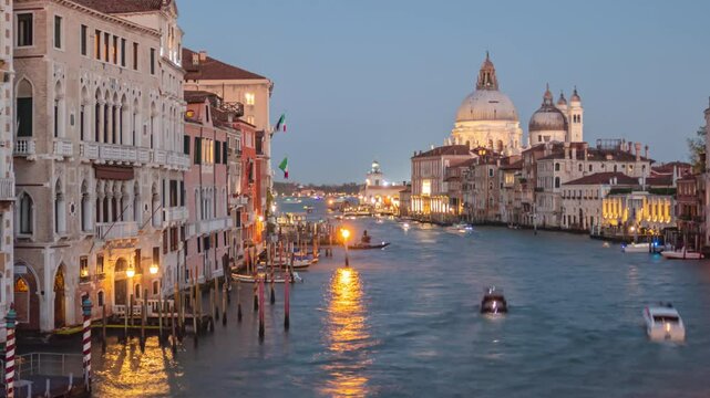 Day to night transition time lapse Grand Canal traffic and Basilica di Santa Maria della Salute, view from Accademia bridge, Venice, Italy