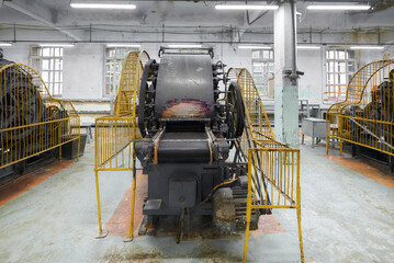 Discovering the intricate workings of a vintage carding machine in an antique textile workshop