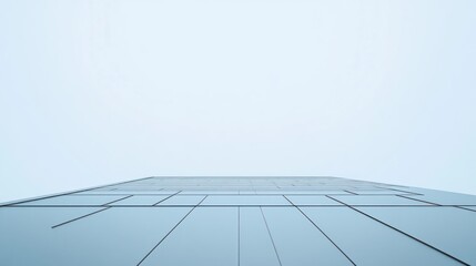 Obraz premium Low-angle view of a modern building's facade against a pale sky.