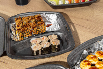 Fried sushi tempura in box on wooden table. Sushi delivery at home. Sushi set