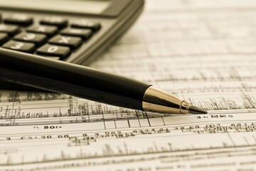 Analysis of financial documents with a calculator and pen in a professional setting