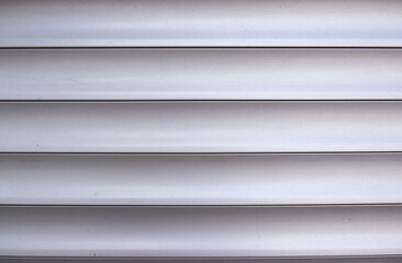 Fototapeta premium Photo of horizontal aluminum slats of a garage door. Horizontal lines, aluminum slats, background, texture. Garage door, detail.