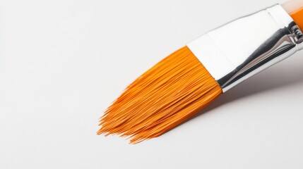 close up of an orange paint brush on a white background