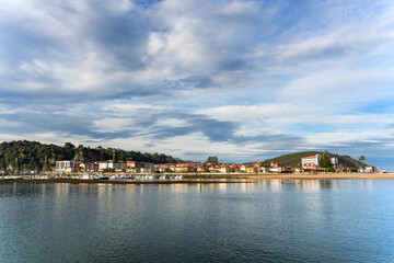 Ribadesella reflecting on the calm waters of sella river in asturias, spain