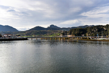 Obraz premium Bridge crossing sella river in ribadesella, asturias, spain, under cloudy sky