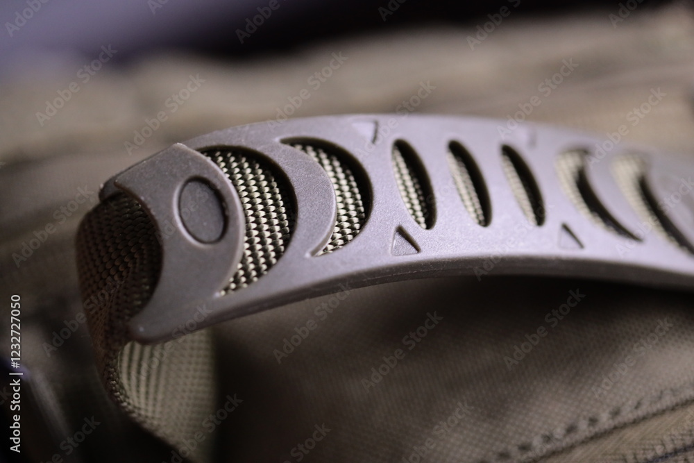 Poster a close-up shot of a metal object attached to a backpack, suitable for use in outdoor or travel-them