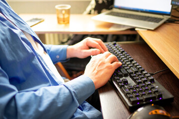 doctor in a blue shirt typing on a computer