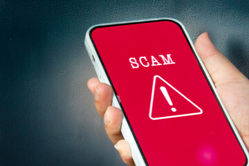 A female user reacts to a scam alert notification on her phone, symbolizing digital safety and online threat detection.