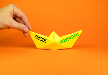 Suicide prevention symbol. Concept words Suicide prevention on beautiful yellow paper boat....