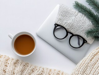 cozy winter work from home setup with coffee, laptop, glasses, and knitted blanket