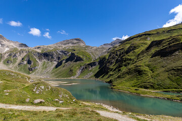 Fototapeta premium The Grossglockner mountain range in Austria with a winding road leading to the lake.