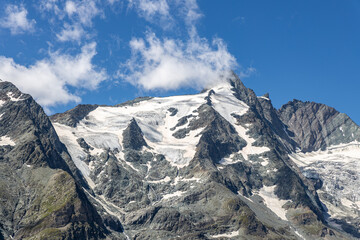 Obraz premium The Grossglockner mountain range with snow on the peaks and a blue sky