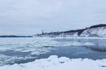 Cove in the partly frozen St. Lawrence river and the Saint-Michel-de-Sillery church dominating a...