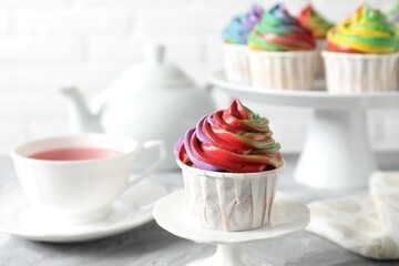 Delicious cupcake with colorful cream on grey table, closeup
