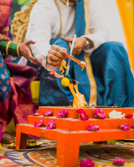 Hindu wedding Havan ceremony, where the bride and groom offer ghee into the sacred fire. The decorated altar, vibrant attire, and ritual flames symbolize purification, blessings, and divine energy.
