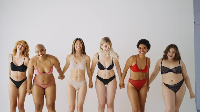 Beautiful women wearing lingerie posing for body positive concepts - Multiethnic group of female adults celebrating body acceptance, individuality, self-esteem.
