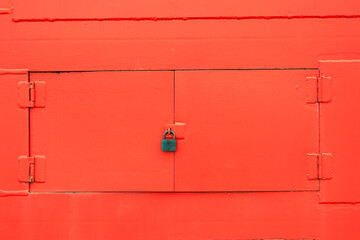 Close up red metal windows on red wall with old lock.