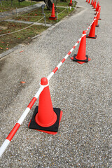 row of orange fluorescent, reflex traffic cones on road