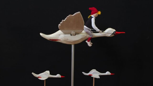 little boy nils flying on a white goose