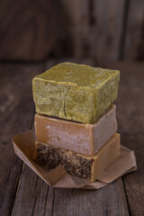 Bar soap of different colors on old wooden background