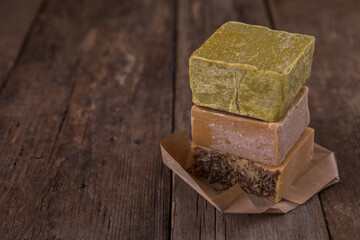 Bar soap of different colors on old wooden background