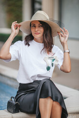 Portrait of fashion beautiful woman in straw hat outdoors in the city