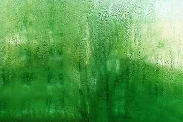 wet glass. textured green background.